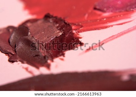 Smears of dark pink shimmery lipstick. Texture of lipstick close-up with soft focus