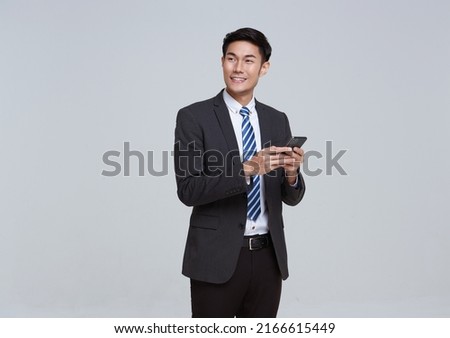 Handsome and friendly face asian businessman smile in formal suit his using smartphone on white background studio shot. Royalty-Free Stock Photo #2166615449