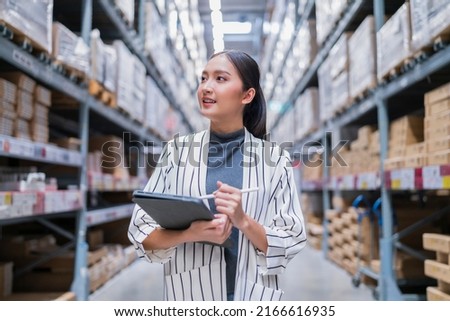 asian female business owner using digital tablet checking amount of stock product inventory on shelf at distribution warehouse factory.logistic business shipping and delivery logistic service Royalty-Free Stock Photo #2166616935