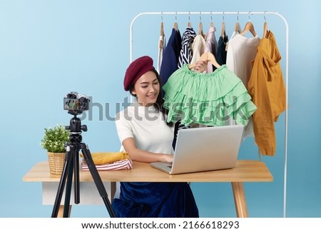 Asian young woman live streaming showing clothes in front of camera for sale fashion clothing is blogger presenting for social people.Her is influencer in social online.