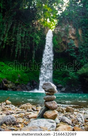 Arrangement of standing stones against waterfall background