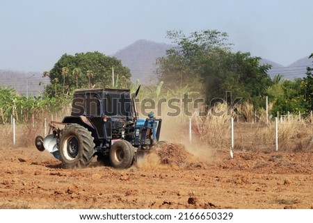 Tractor with Plougher and Grader Working