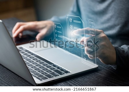 Businessman using computer laptop on e document on digital tablet , E-signing on e document and virtual notepad on virtual screen , electronic signature , paperless office concept