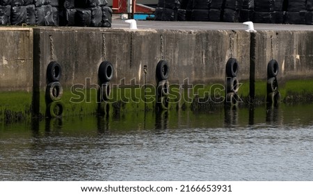 Harbour wall with old tyre buffers and bollards