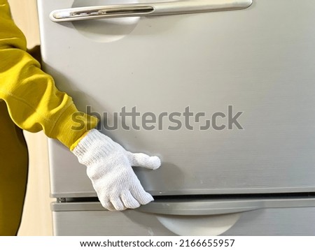Hands with work gloves to move the refrigerator Royalty-Free Stock Photo #2166655957
