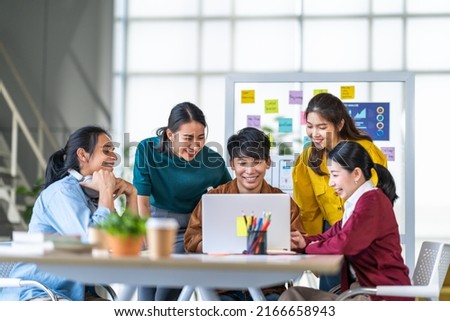 Young happy Asian business man, woman work together in start up office. Creative team brainstorm meeting, internet technology, businesspeople colleague partnership, or office coworker teamwork concept Royalty-Free Stock Photo #2166658943