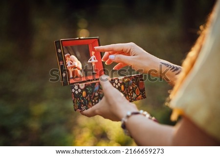 Childhood Trauma In Adults. Outdoor portrait of Woman holding a music box in her hands Royalty-Free Stock Photo #2166659273