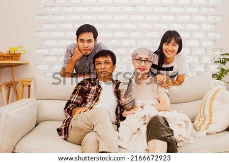 Portrait of four people in a warm family : Happy Asian families take pictures together to commemorate memories and gifts in a home with lovely parents, brother and sister.