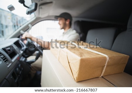 Delivery driver driving van with parcels on seat outside the warehouse Royalty-Free Stock Photo #216667807