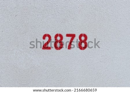 Red Number 2878 on the white wall. Spray paint.
