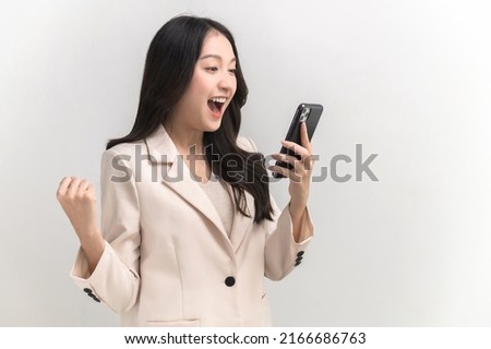 Portrait photo of young beautiful Asian woman feeling happy or surprise shock and holding smart phone with black empty screen on white background can use for advertising or product presenting concept. Royalty-Free Stock Photo #2166686763