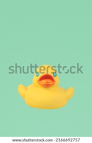 Yellow rubber duck on an emerald background.