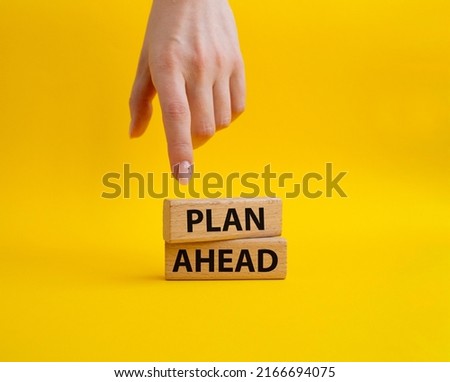 Plan ahead symbol. Wooden blocks with words 'Plan ahead'. Beautiful yellow background. Businessman hand. Business and 'Plan ahead' concept. Copy space. Conceptual image