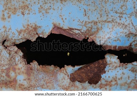 Fragment of rusty metal sheet. After many years of operation, corroded metal destroyed. rusty metal surface texture with holes metal corrosion. Selective focus. Royalty-Free Stock Photo #2166700625