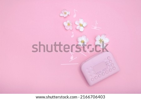 Retro pink player and pink flowers with drawing musical notes on pink background flat lay with copy space. Minimalism illustration