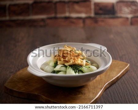 Braised Baby Cabbage in Superior Stock served in a dish isolated on mat side view on dark background