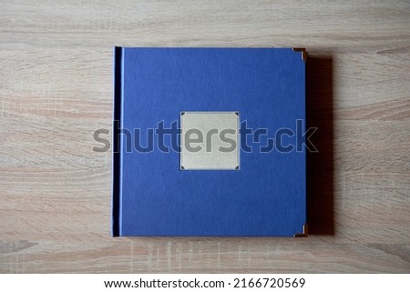 Wood blue wedding photobook on wooden table background, copy space. Mockup template. Top view, flat lay