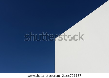 White wall of a house in Crete (Greece) against a blue sky after sunrise 