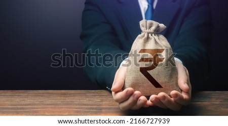 Businessman holds out indian rupee money bag. Getting a grant. Easy Money. Salary, benefits, profit. Attracting investments. Deposit savings. Cashback. Banking and crediting. Mortgage, loan approval. Royalty-Free Stock Photo #2166727939