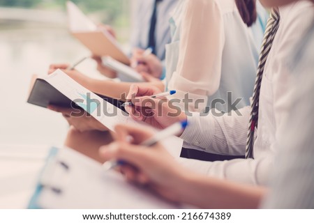 Close-up of business people making notes during the meeting Royalty-Free Stock Photo #216674389