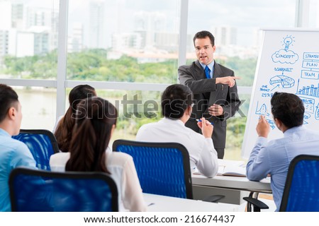 Middle-aged businessman conducting seminar for his colleagues Royalty-Free Stock Photo #216674437