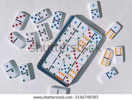 Domino game on a white table. dominoes and a box. Domino effect.