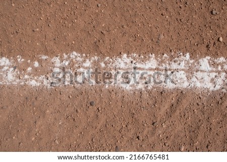 close up of a baseball diamond with the white line of chalk on clay dirt