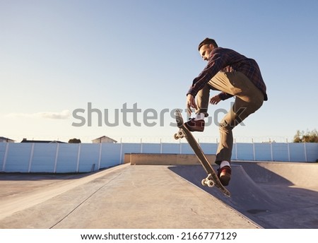 A rad day at the skate park. A young man doing tricks on his skateboard at the skate park. Royalty-Free Stock Photo #2166777129