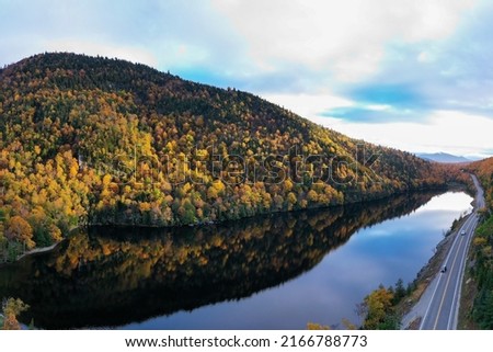 Peak fall foliage in Keene, New York by Cascade Lake. Royalty-Free Stock Photo #2166788773