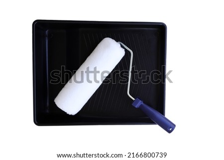 Paint brush on its roller tray isolated on white background