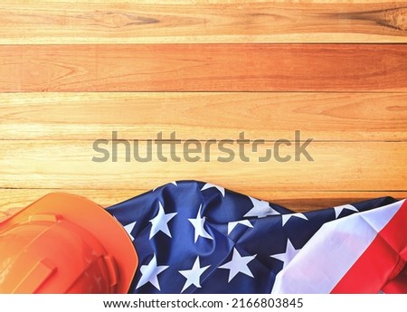 Top view with orange safety helmet and usa flag on wood table background. labor day and independence day concept.