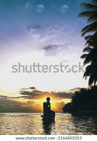 kid who chilling while watching sunset near the beach
