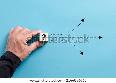 Male hand puts a wooden cube with question mark. Different solution alternatives for an emerging problem or alternative path options. Royalty-Free Stock Photo #2166856063