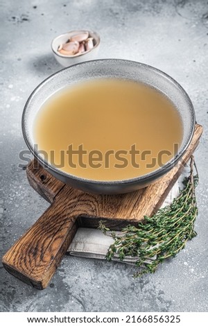Bone meat chicken broth in a plate. Gray background. Top view.