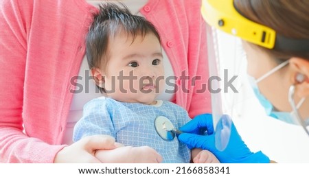 authentic shot of asian mother and infant in pediatrics clinic - doctor examine baby health by stethoscope and physician