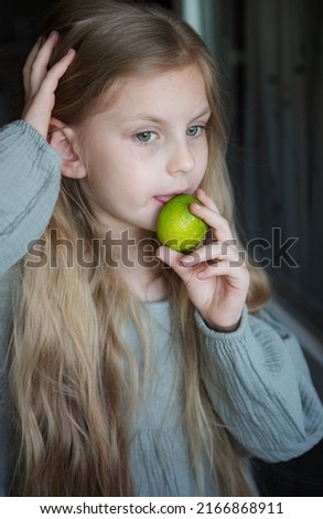Beautiful little girl with lime in her hands