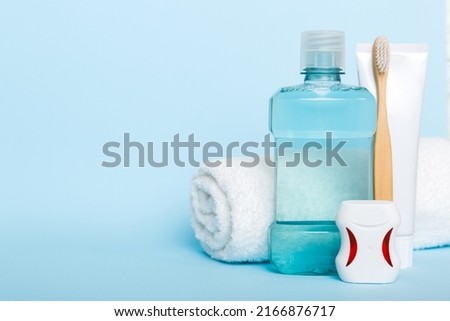 Mouthwash and other oral hygiene products on colored table top view with copy space. Flat lay. Dental hygiene. Oral care products and space for text on light background. concept. Royalty-Free Stock Photo #2166876717