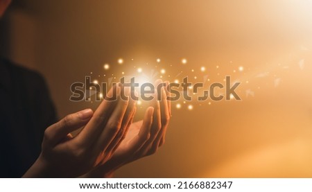Hand praying with magic light that flows through on orange bokeh background. Royalty-Free Stock Photo #2166882347