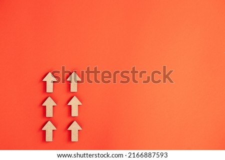 Wooden arrows point to the up on red background