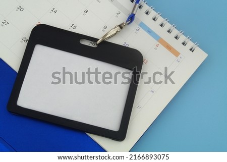 Access to event concept. Black badge with calendar on blue background close-up.