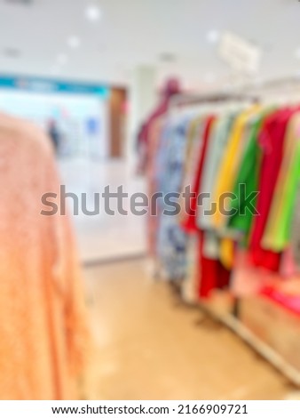 Defocused Abstract Background aisle of female clothes store 
hanging on rack in front of the store inside modern Shopping Mall or Shopping Center. with vintage tone effect
