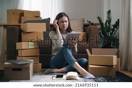 Asian woman think hard serious working laptop computer at home selling online start up small business owner, e-commerce ideas concept.
