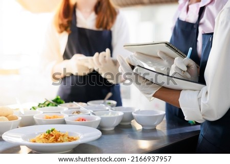 take note on book. Cooking class. culinary classroom. group of happy young woman multi-ethnic students are focusing on cooking lessons in a cooking school.  Royalty-Free Stock Photo #2166937957