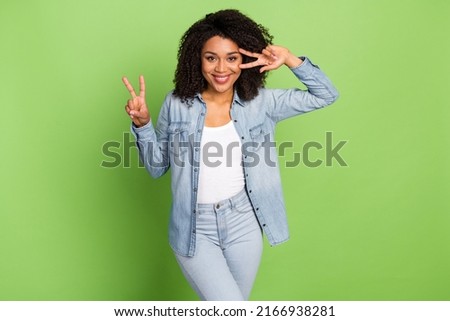 Photo of young pretty woman good mood show fingers peace v-symbol travel isolated over green color background