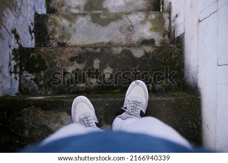 two feet wearing blue white shoes walking down the stairs