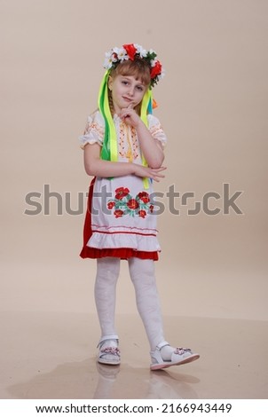 A girl dressed in Ukrainian traditional clothes, vyshyvanka. flowers on the background. Ukrainian little girl.