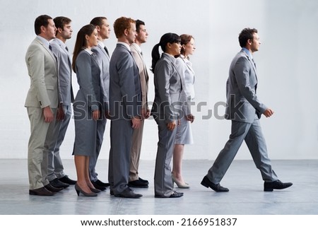 Leading by example. A young business manager walking ahead of his colleagues - Leadership. Royalty-Free Stock Photo #2166951837