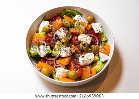Fresh sliced vegetables for salad in a plate on a white background