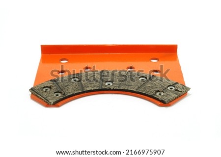 Hay baler spare part knotter left support plate and brake lining, orange, front view of hay baler spare part, isolated on white background   