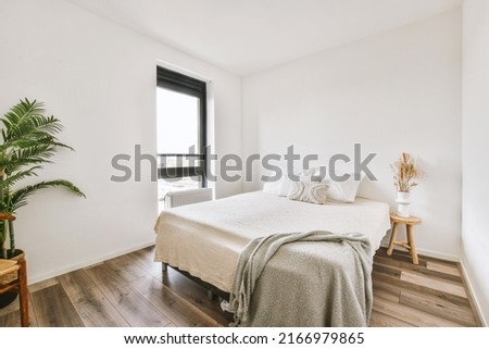Minimalist interior design of small bedroom with soft bed placed in corner with lamp illumination Royalty-Free Stock Photo #2166979865